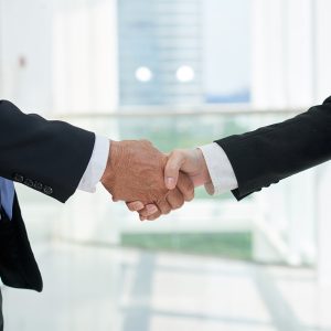Close-up image of business partners shaking hands at meeting